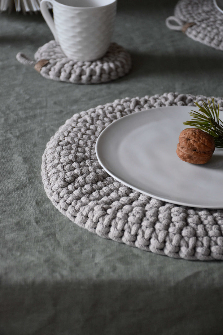 Gray woven placemat with a white plate and cup on a textured surface