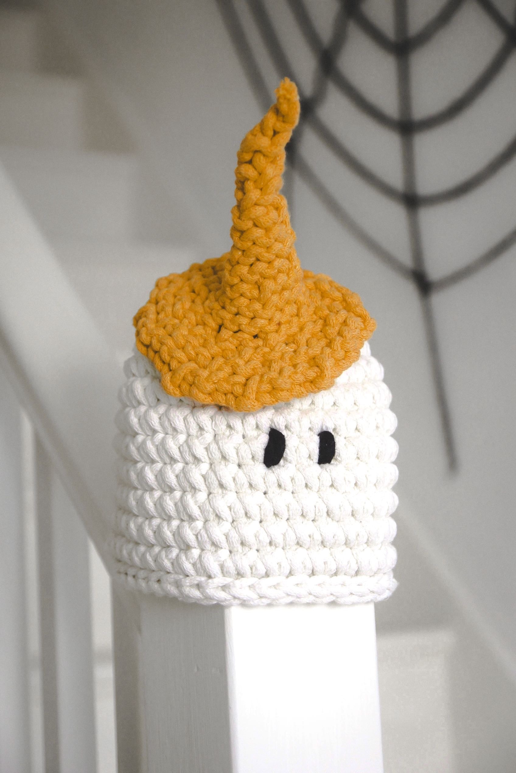 Crocheted pumpkin with white base and orange top on a white background