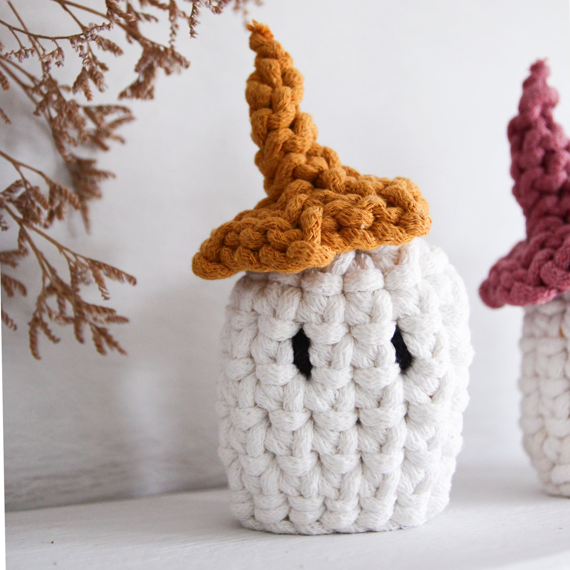 Knitted ghost with a brown hat on a white background