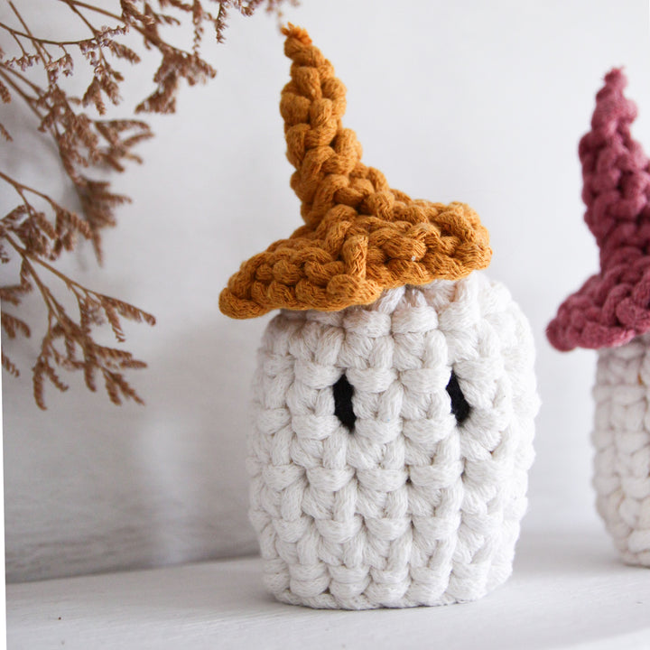 Knitted ghost with a brown hat on a white background