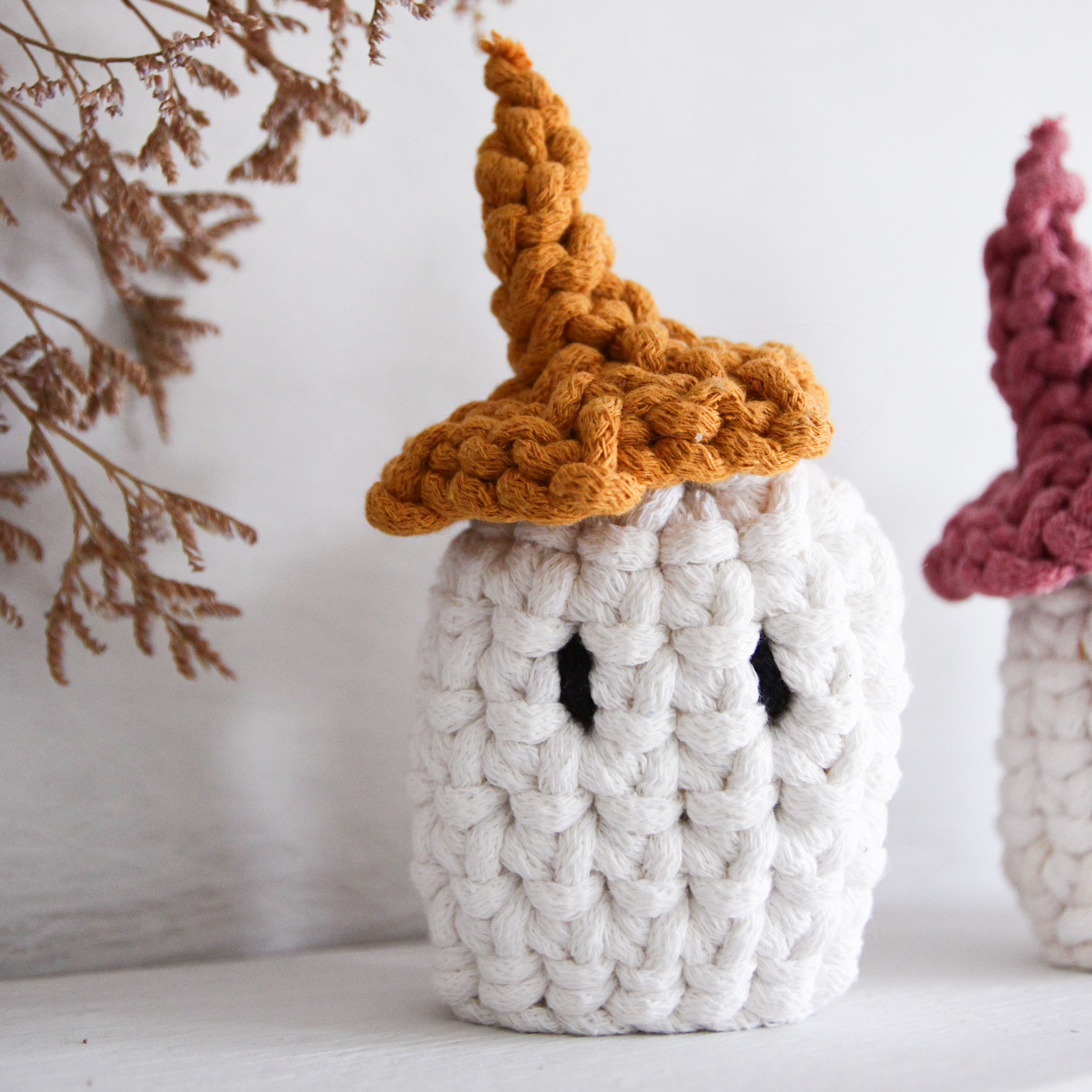 Knitted ghost with a brown hat on a white background