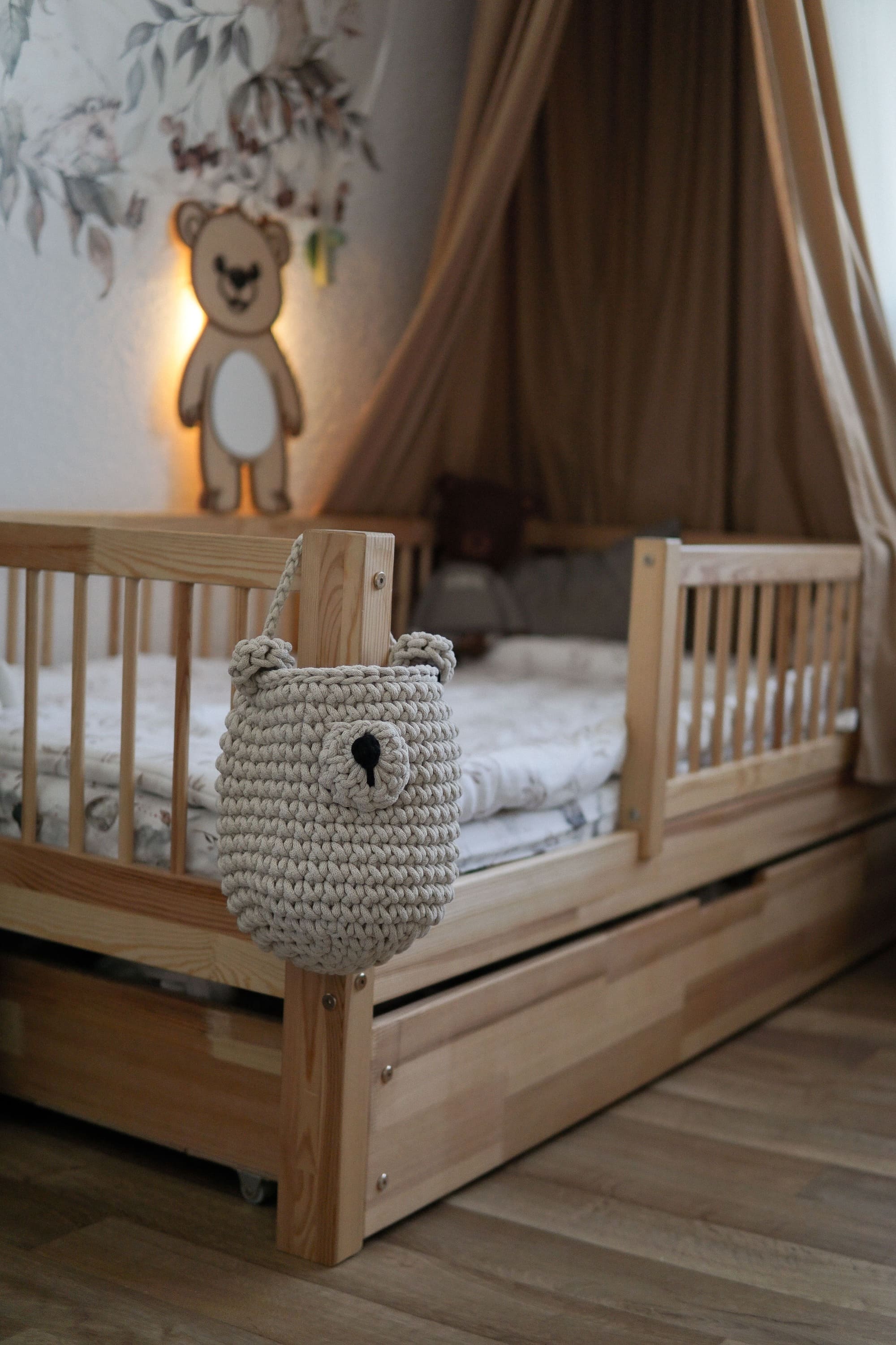 crochet hanging bear basket hanging on the wooden bed