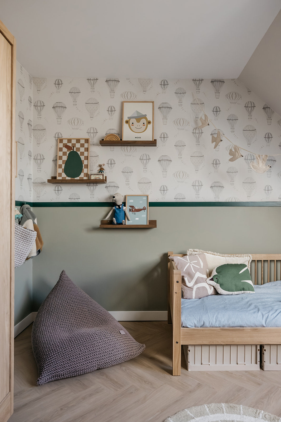 Children's bedroom with wooden bed, purple pillow, and patterned wallpaper.