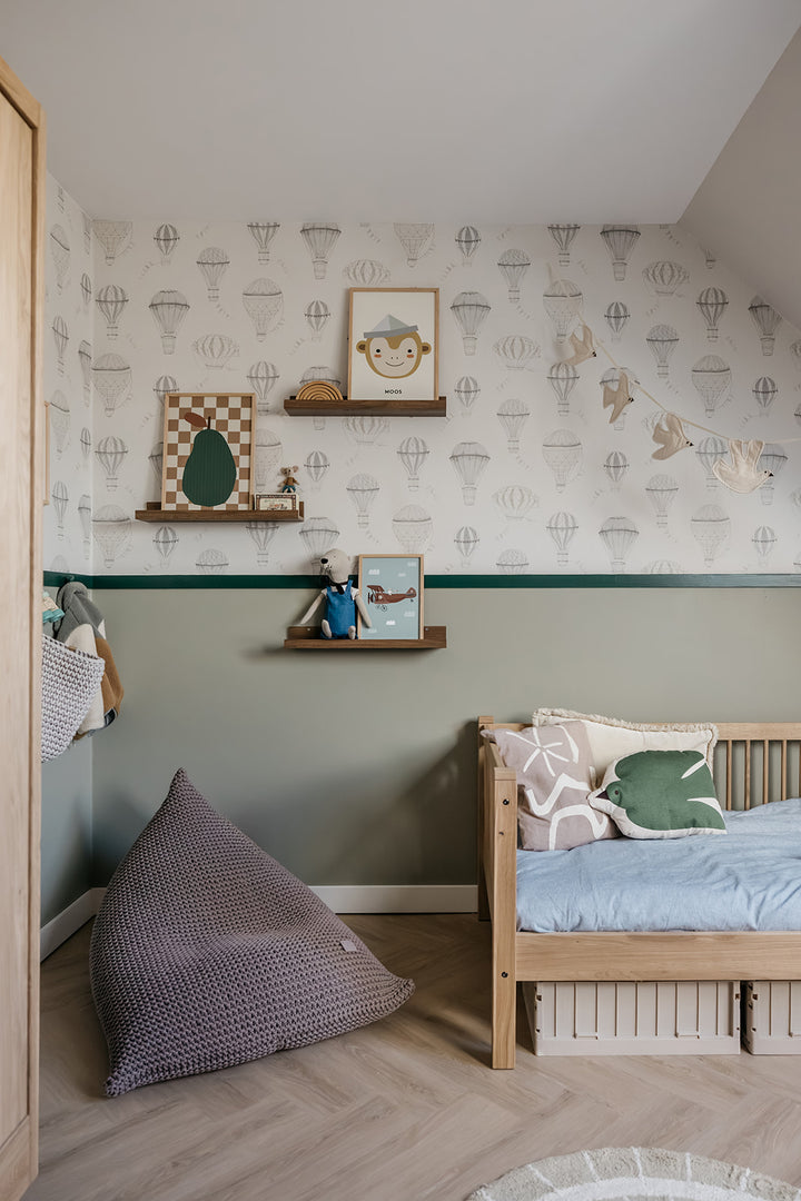 Children's bedroom with wooden bed, purple pillow, and patterned wallpaper.