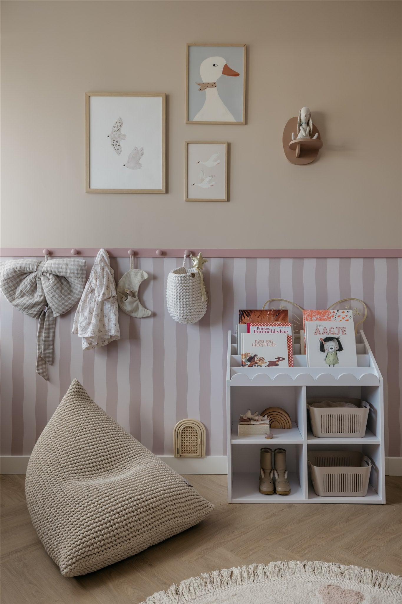 Children's room with striped wallpaper, shelves, and wall art.