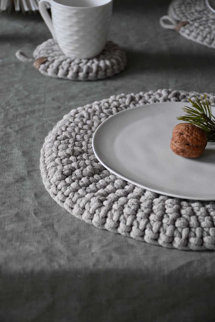 Gray woven placemat with a white plate and cup on a textured surface