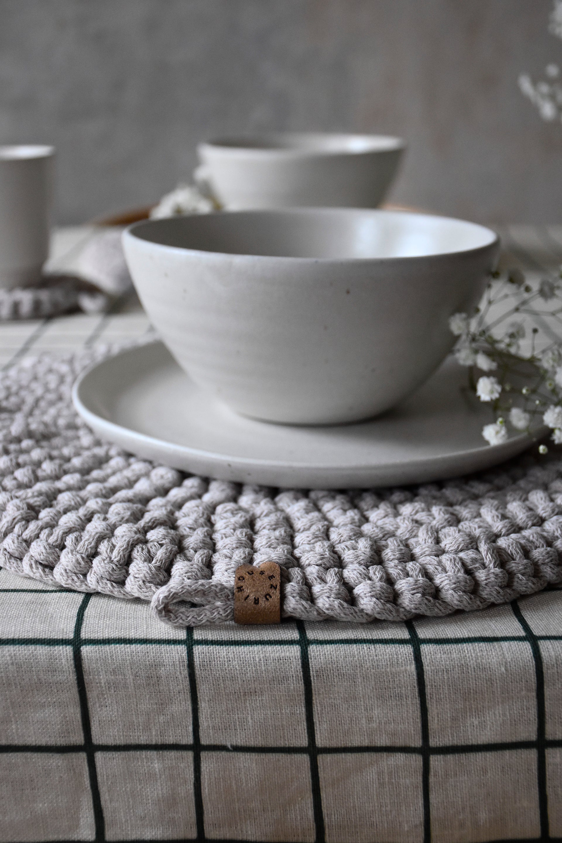 White ceramic bowl and saucer on a textured surface with a neutral background