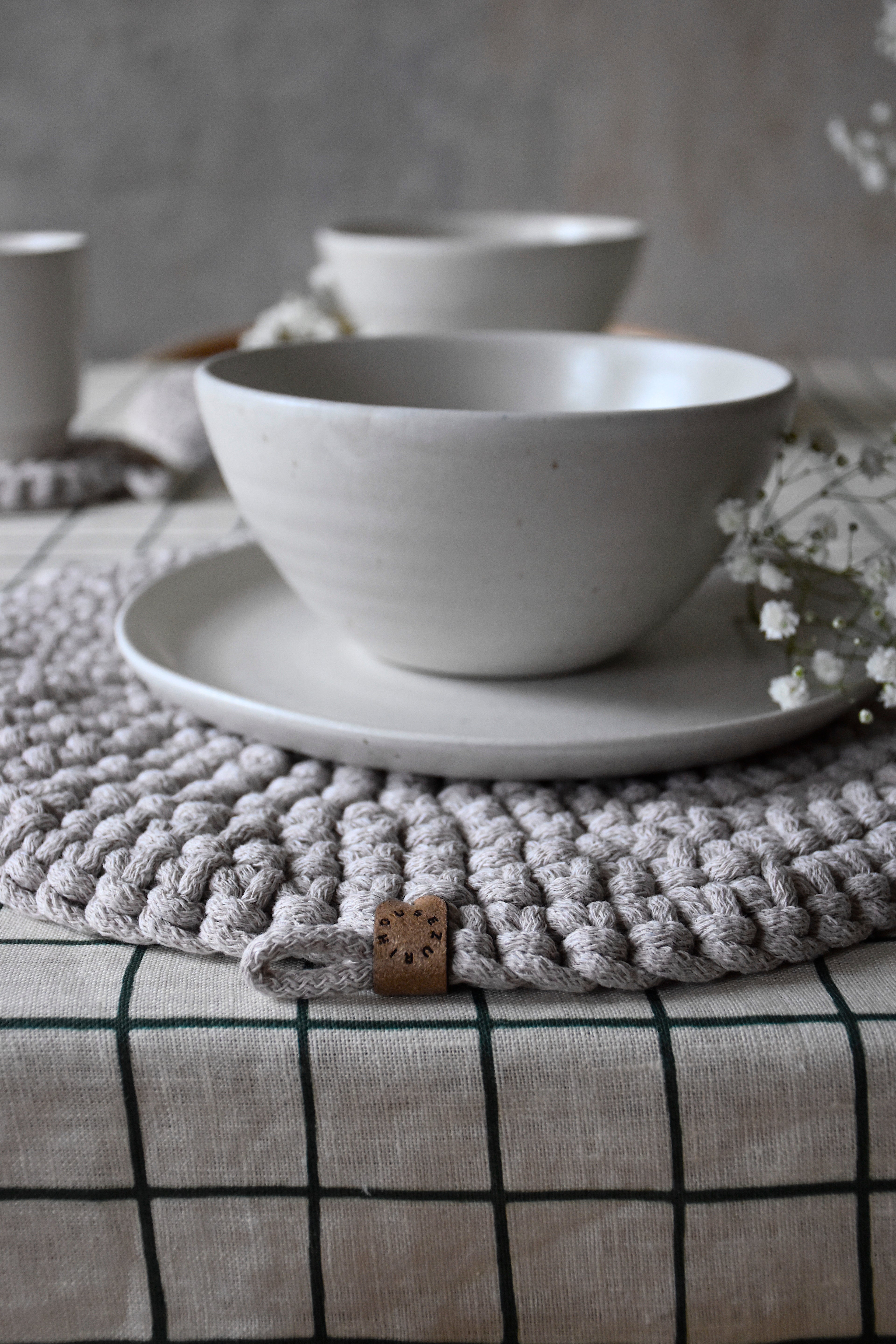White ceramic bowl and saucer on a textured surface with a neutral background