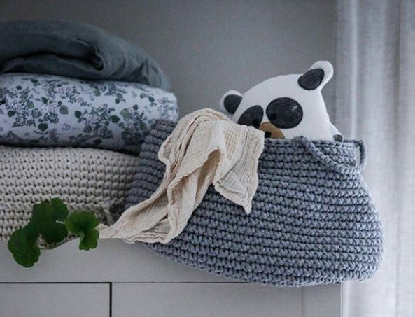crochet basket with soft toys in scandinavian style bedroom