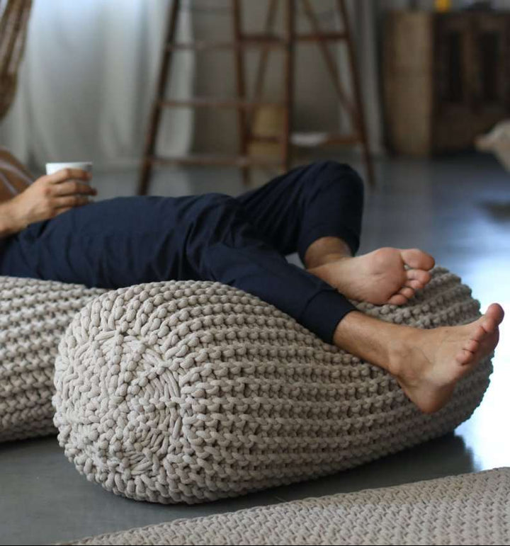 Chunky knitted footrest with human feet placed on