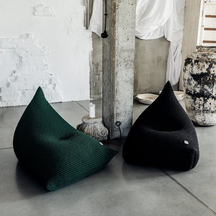 Handcrafted bottle green bean bag in soft lighting against a neutral backdrop
