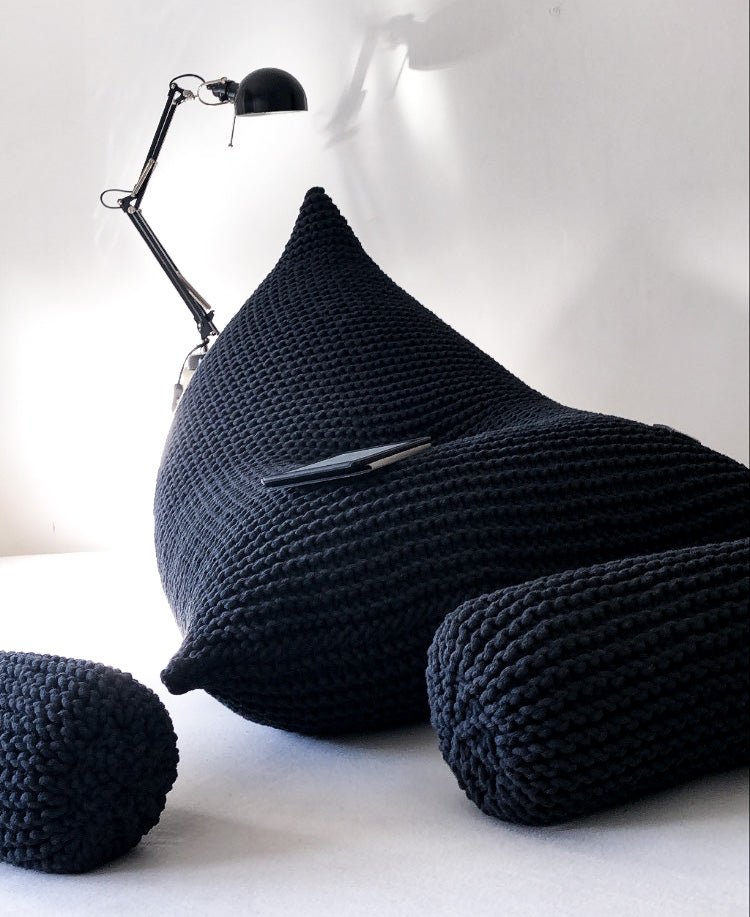 Sculptural charcoal bean bag showing dense knit pattern and rounded form