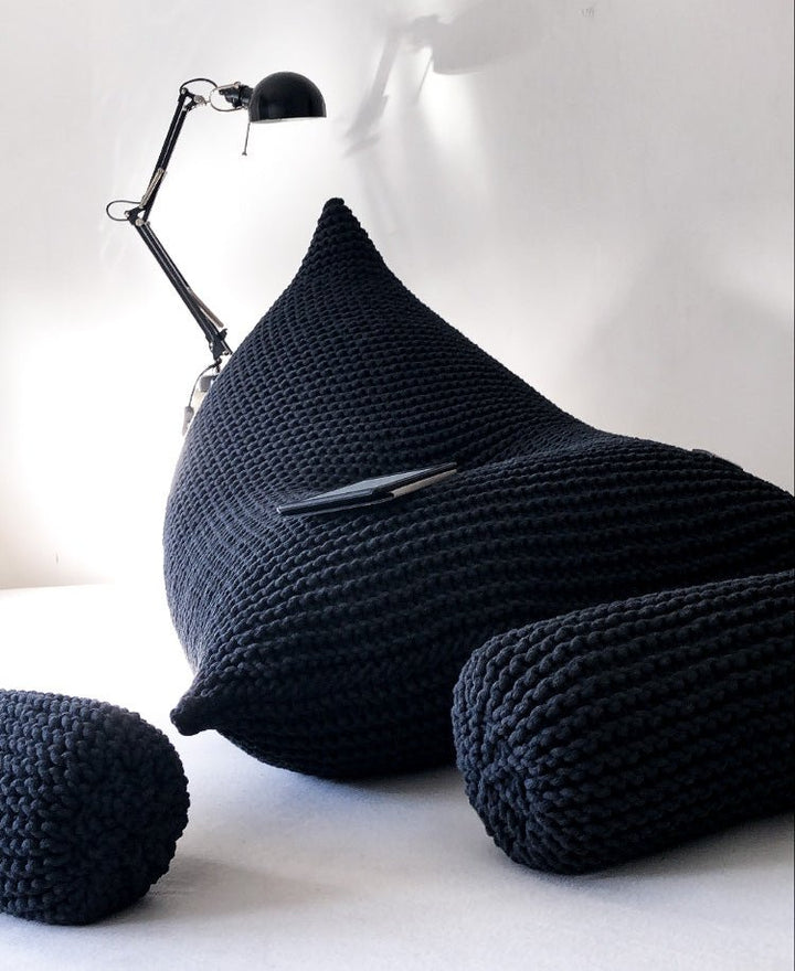 Sculptural charcoal bean bag showing dense knit pattern and rounded form