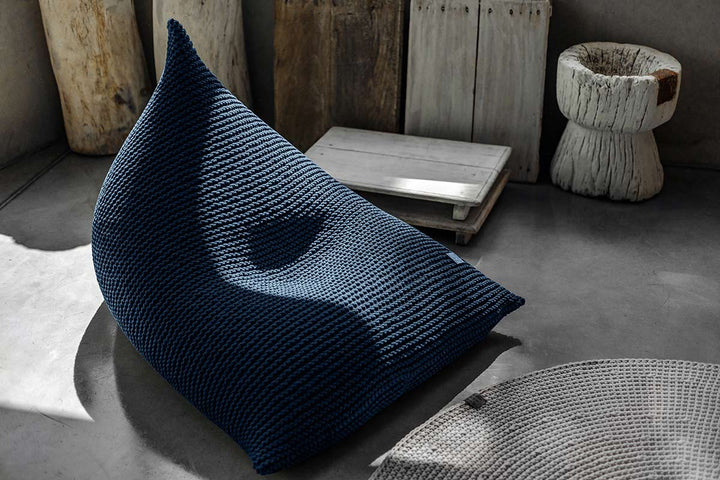 Denim blue hand-knitted bean bag in studio lighting with subtle highlights