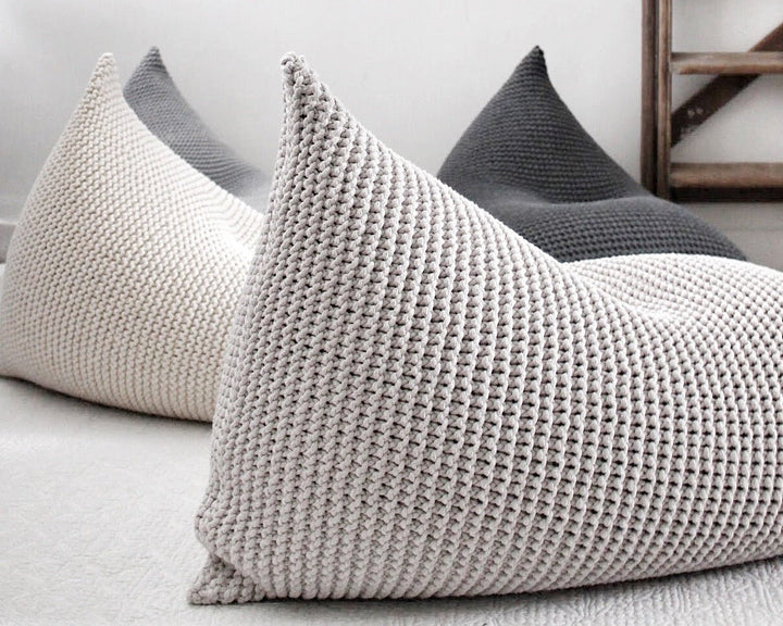 Detail view of an oatmeal bean bag’s chunky knit and curved silhouette