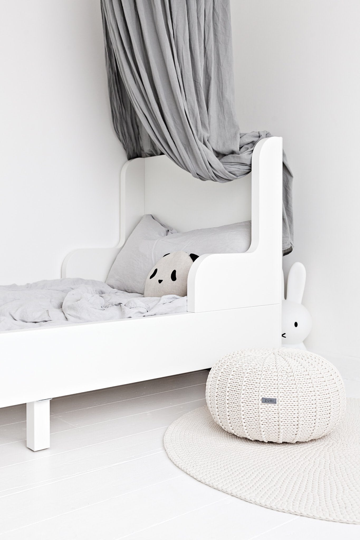 Soft round pouffe on wooden floor