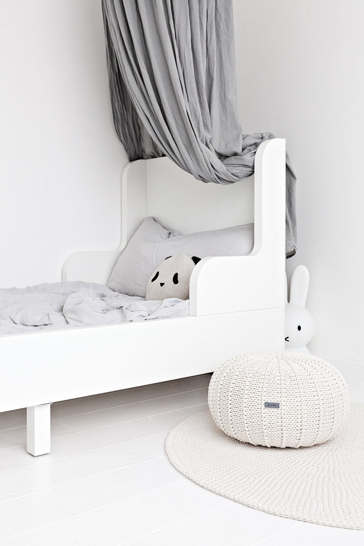 Soft round pouffe on wooden floor