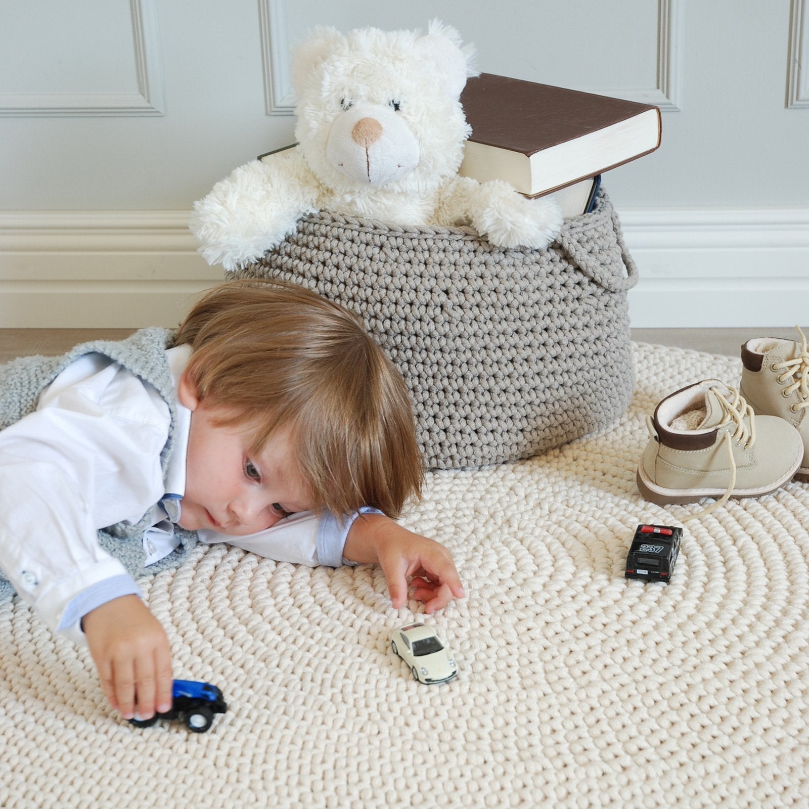 Neutral beige cotton basket used for organising children's toys in a playroom