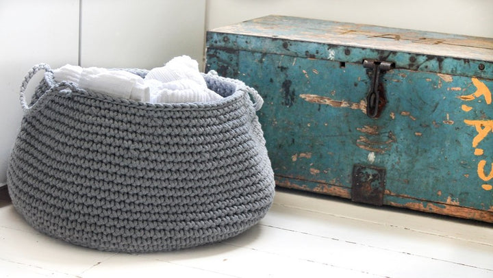 Elegant dark grey storage basket used for bathroom organisation and towel display