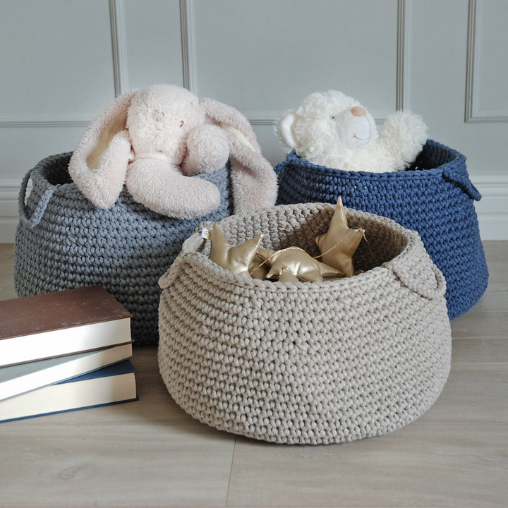 Blue cotton basket with handles, neatly storing soft toys in a modern kids’ room