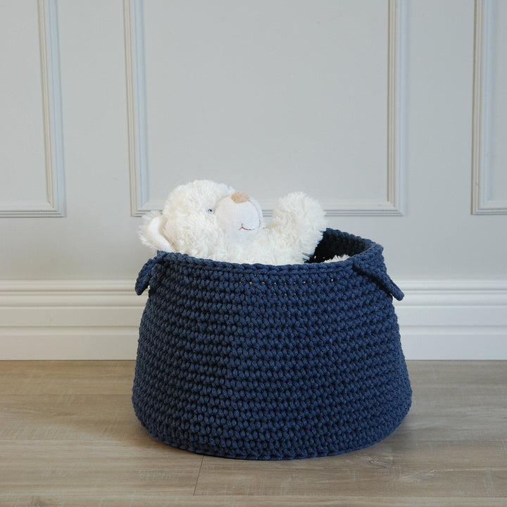 Denim blue crochet basket filled with toys and books in a stylish nursery