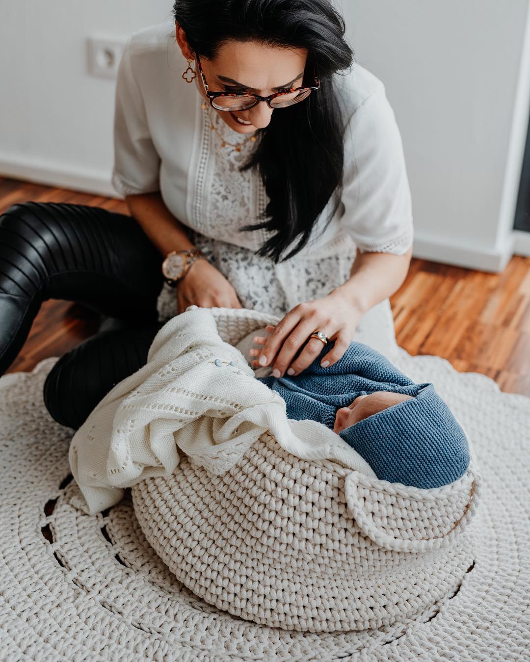 Ivory-toned storage basket as a newborn photoshoot item holding a baby