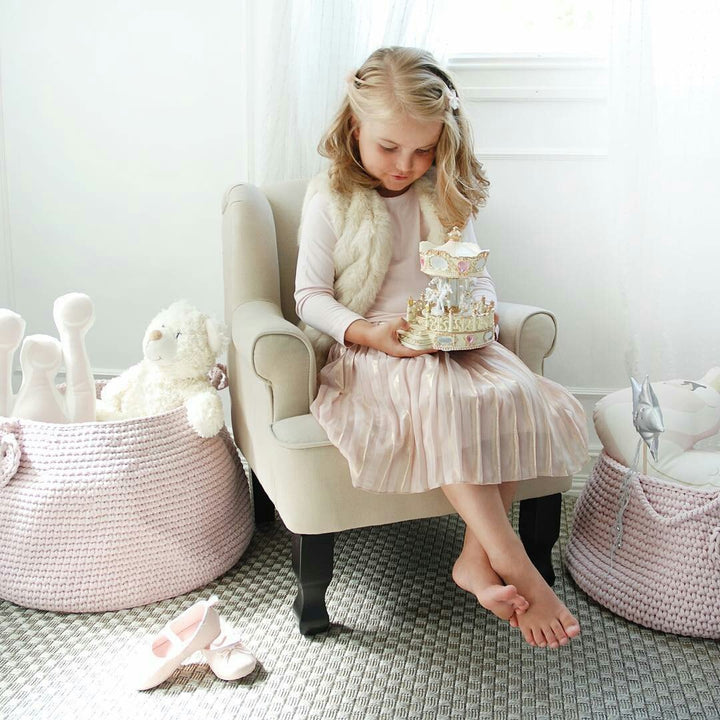 Delicate blush crochet basket used for toy organisation in a child’s bedroom